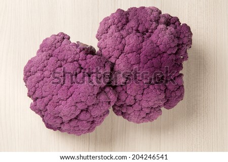 Purple cauliflowers over a wooden surface