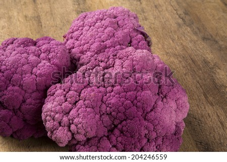 Some purple cauliflowers over a wooden surface