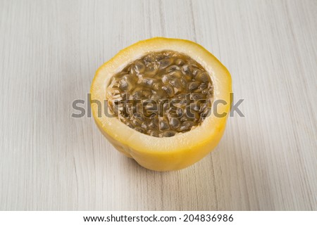 A passion fruit cut in a half over a wooden surface