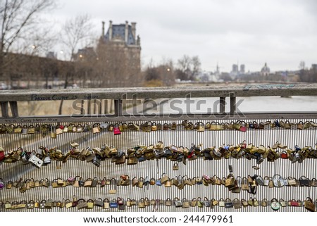 PARIS - DECEMBER 25: Love padlocks, a tradition of the romantic Paris, representing eternal love of the couples, who lock padlocks on a bridge over the Seine river in Paris, France, December 25, 2014.