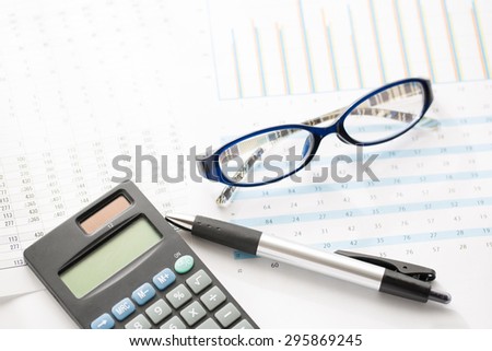 Business still-life of a pen, calculator, glass