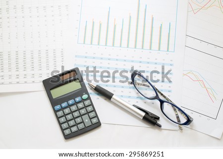 Business still-life of a pen, calculator, glass