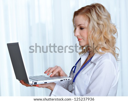 Portrait of a beautiful young doctor with laptop computer