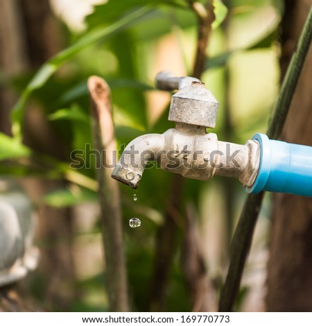 old water tap with water drop
