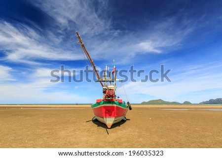 Thai fishing boat and blue sky on the beach used as a vehicle for finding fish in the sea