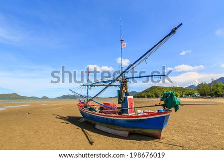 Thai fishing boat and blue sky on the beach used as a vehicle for finding fish in the sea