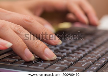 Female hand typing on laptop PC.