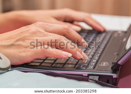 Female hand typing on laptop PC.