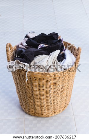 clothes in a wooden laundry basket.