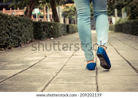 Woman walking on foot path. Vintage filter.