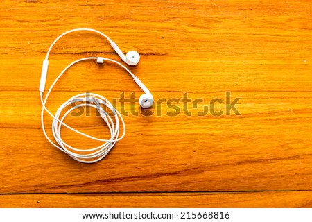 Modern portable audio earphones on wood board