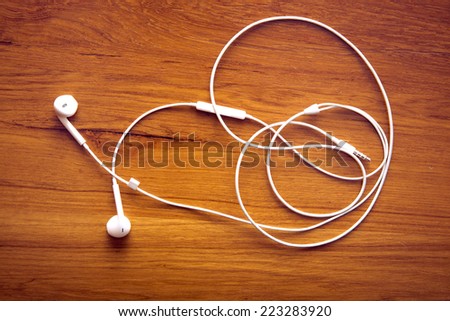 Modern portable audio earphones on wood board