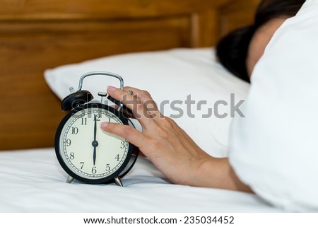 Concept alarm clock with sleep woman in comfort bed.