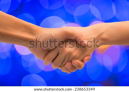 Business man and woman make hand shake with abstract bokeh christmas light
