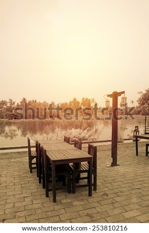 Empty dinner table at riverside. Vintage filter