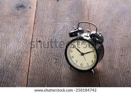 Alarm clock on grunge wood table.