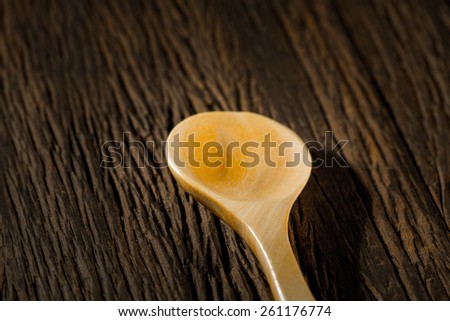Wood spoon on grunge wood background.