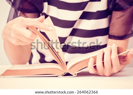 Education concept. Closeup woman hand action reading book. Vintage filter