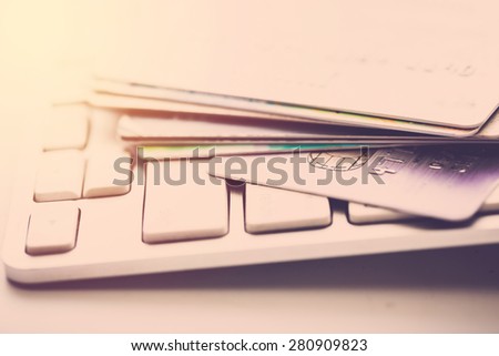 Credit card on computer keyboard. Vintage filter