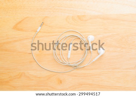 Modern earphone on wood board.