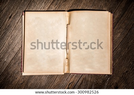 Old open book on table with pencil.