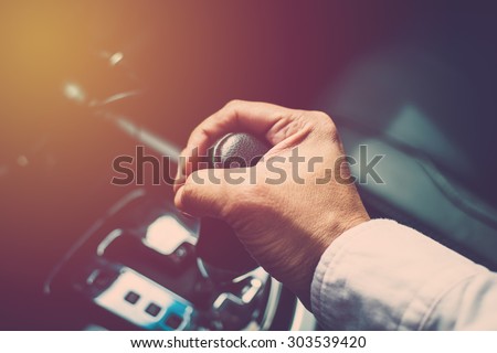 Business man driver hand shifting the gear stick. Vintage filter