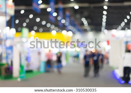 Blur of people in exhibition hall event.