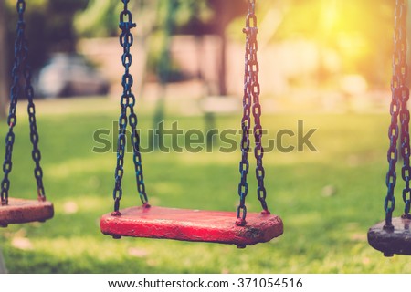 Empty chain swing in playground. Vintage filter