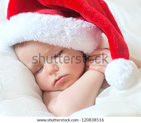 little baby sleeping in a red cap of Santa Claus
