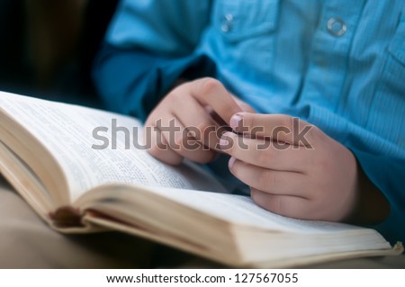Child hands are on the open book