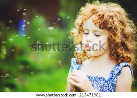 Beautiful little curly girl blowing dandelion horizontal shot Beautiful little curly girl blowing dandelion horizontal shot