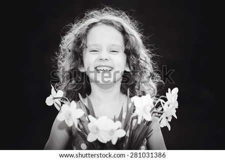Laughing girl with a flower in her hand. Black and white photo.