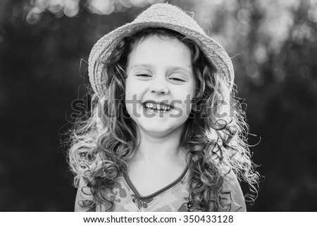 Black and white portrait of a funny little girl. Child missing tooth. Happy childhood concept.