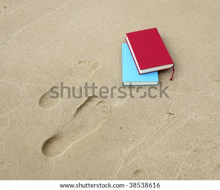 Two books lying beside two footprints.