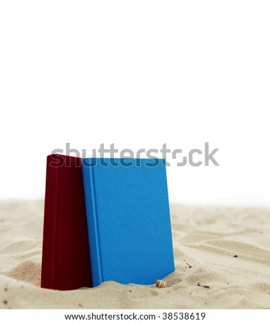 Two books standing in sand isolated on white.