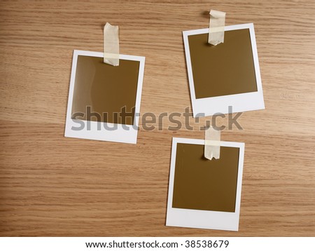 three photos taped on wooden desktop