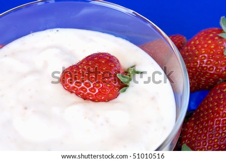 Food & Drinks - Desserts. Bowl of yogurt with strawberries. Close view.