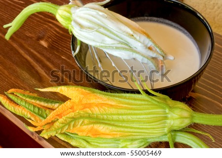 Food And Drinks - Italian Food - Fried zucchini flowers preparation - Closeup of zucchini flower in the batter.