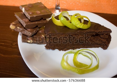 Food And Drinks - Desserts. Piece of chocolate cake decorated with lime peel and chocolate pieces.