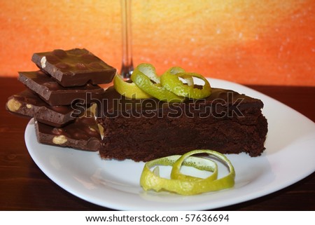 Food And Drinks - Desserts. Piece of chocolate cake decorated with lime peel and chocolate pieces.