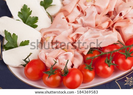 Plate with mortadella, mozzarella and cherry tomatoes, traditionally Italian food.