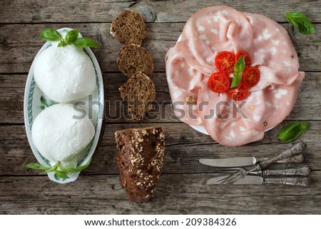 Fresh Italian appetizer:  with sliced mortadella, mozzarella and wholemeal bread with seeds. Overhead shot.