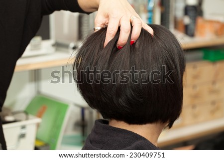 Hairdresser styling the hair of client in a salon.