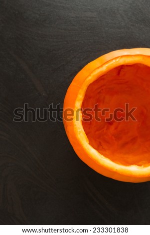 Food backgrounds - Overhead shot of half empty pumpkin on black background.