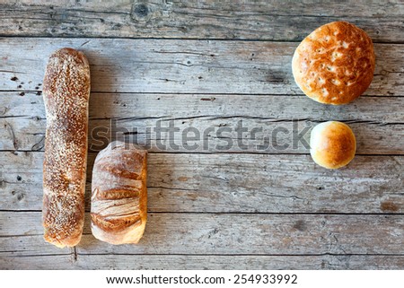 Various types of Italian bread, overhead shot, on wood background.