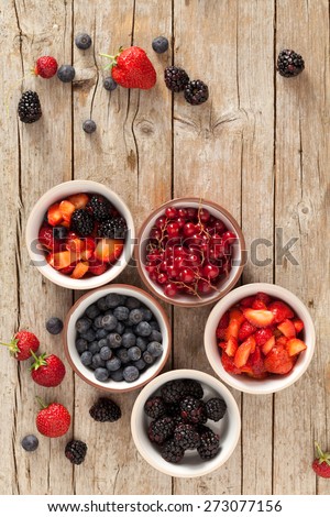 Soft fruits in bowls photographed from above: strawberries, blackberries, blueberries and redcurrants.
