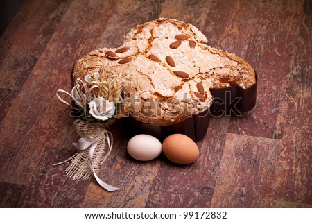Traditional Italian desserts for Easter - Easter dove and eggs, on wood table.