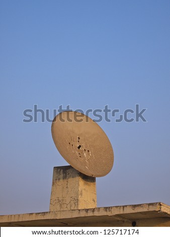 old satellite dish on the roof of building