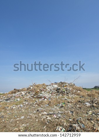 small pile of garbage in blue sky and sunlight