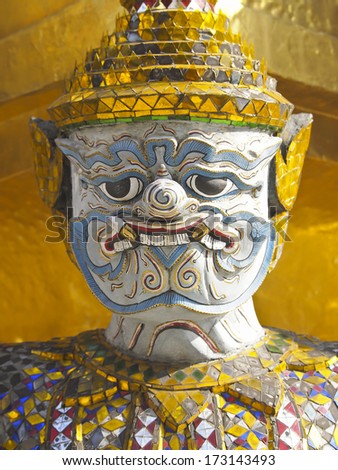 closeup face of guardian giant at stupa base in grand palace, phrakaew temple, Bangkok, Thailand